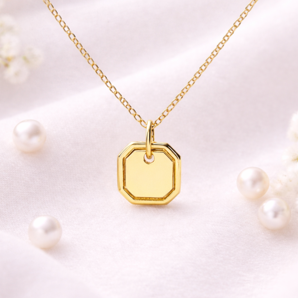 Gold necklace with a hexagonal pendant on a light background
