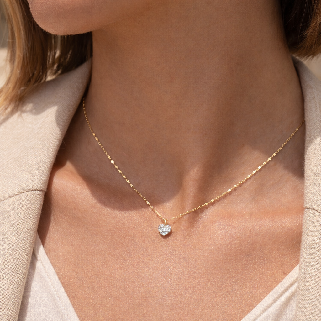 Gold necklace with a heart-shaped pendant worn by a person